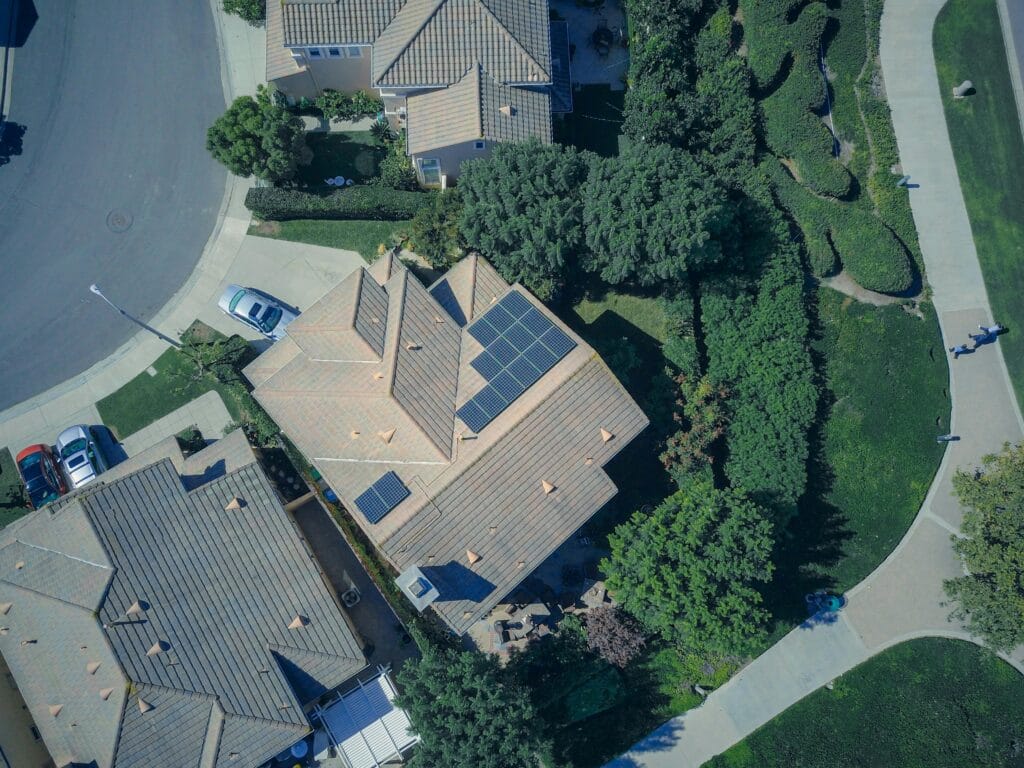 An aerial view showcasing modern suburban houses equipped with solar panels for Ecavix home energy storge